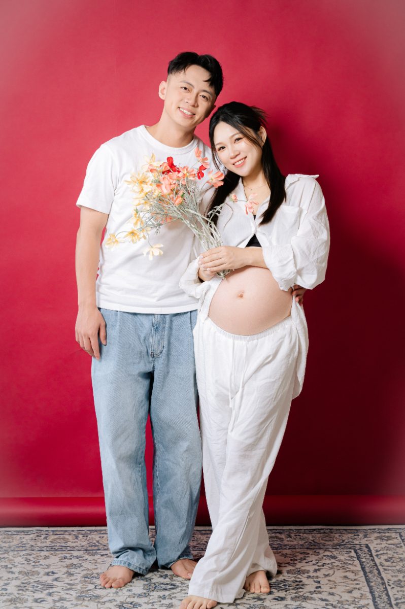 台中孕婦寫真：紅色背景與捧花的夫妻合照